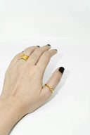 Hand with gold rings, black nail polish, for cleaning jewelry with mild soap