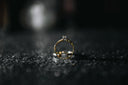 A delicate gold engagement ring with a central diamond and accent stones in fine art gold jewelry design