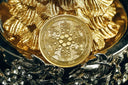 A golden cardano ada coin with intricate circuit patterns on a gold-plated surface related to art gold jewelry