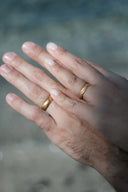 A pair of gold jewelry wedding bands with smooth and engraved finishes featured in fine jewelry engagement rings trends