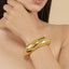 A close up of a woman wearing a gold bracelet