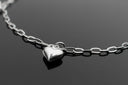 a silver heart necklace on a black surface