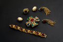 Gold-toned victorian jewelry bracelet with faceted red and clear gemstones in an ornate vintage-inspired design.