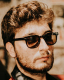 A man with a beard wearing sunglasses and a leather jacket