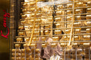 Rows of gleaming gold bangles in jewelry store window