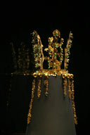 Ornate golden crown with jade accents on display