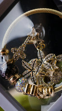 Gold-toned art gold cable bracelet with crystal flower and star charms for engagement rings