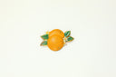 Vibrant orange enamel fruit brooch with leaves, timeless art gold jewelry.