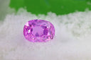Vibrant pink oval-cut cursed gem on white crystals in timeless fine jewelry