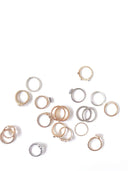 A collection of delicate gold jewelry rings in 18k gold and silver with intricate textures and fine gemstones.