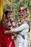 Newlyweds in traditional attire with floral garlands