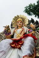 Goddess statue adorned with gold jewelry and flowers