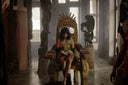 Golden throne with intricate carvings and crown-like backrest, royal jewels art.