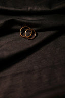 Two interlocking 18k gold wedding rings on dark fabric showcasing fine jewelry and gold jewelry in Everett Massachusetts