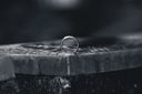 A minimalist silver engagement ring with a polished band on an anvil highlighting fine jewelry traditions in art gold