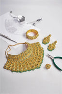 Golden intricately beaded choker necklace with green accents from an everett jewelry store featured in tracing heirloom jewelry.