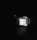 Silver-toned Cartier Santos watch with square face roman numerals and metal bracelet in fine jewelry design article.