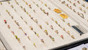 A collection of colorful gemstone rings in 18k gold fine jewelry displayed in a white velvet lined box for engagement trends