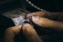 A silver ring with intricate sparkling diamond detailing complements 18k gold jewelry care tips for lasting shine