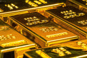 Shiny gold bullion bars with engraved markings and polished finish illustrating gold purity for art gold jewelry trends