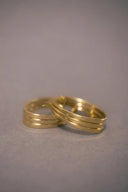 a pair of gold rings sitting on top of a table