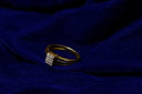 Gold ring with square cluster of clear stones set in intricate textured band featured in 18k gold jewelry article
