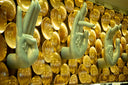 Light blue sculpted hand statues with floral embossing beside golden reflective orbs in art gold jewelry display