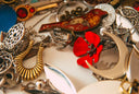 A red enamel bird pendant with intricate gold gear detailing and silver metallic finish in fine gold jewelry style.
