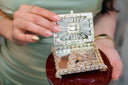 A sparkling silver and crystal-encrusted jewelry box with hidden jewelry compartments holding 18k gold jewelry coins