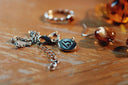 Silver chain necklace with circular embossed logo pendant highlighting art gold jewelry in engagement rings article