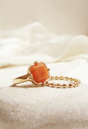 A delicate men’s gold ring with a square-cut orange cabochon stone showcasing fine gold jewelry elegance.