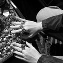 Hands adorned with ornate rings examining jewelry display
