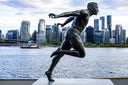 Bronze statue of a male runner in mid-stride highlighting dynamic motion and musculature for fine jewelry inspiration by harry winston