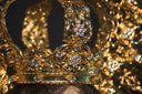 An ornate gold crown featuring intricate filigree and clear gemstones showcasing art gold fine jewelry.