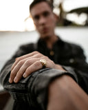 A gold-toned engraved men’s ring with shield design showcasing fine jewelry and art gold craftsmanship.