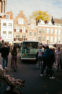 A crowd of people standing around a green van