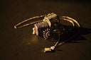 Golden intricate metal necklaces with ornate cylindrical pendants reflecting vintage glamour and jewelry history