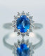 Sapphire and diamond ring with an oval blue gemstone surrounded by smaller diamonds.