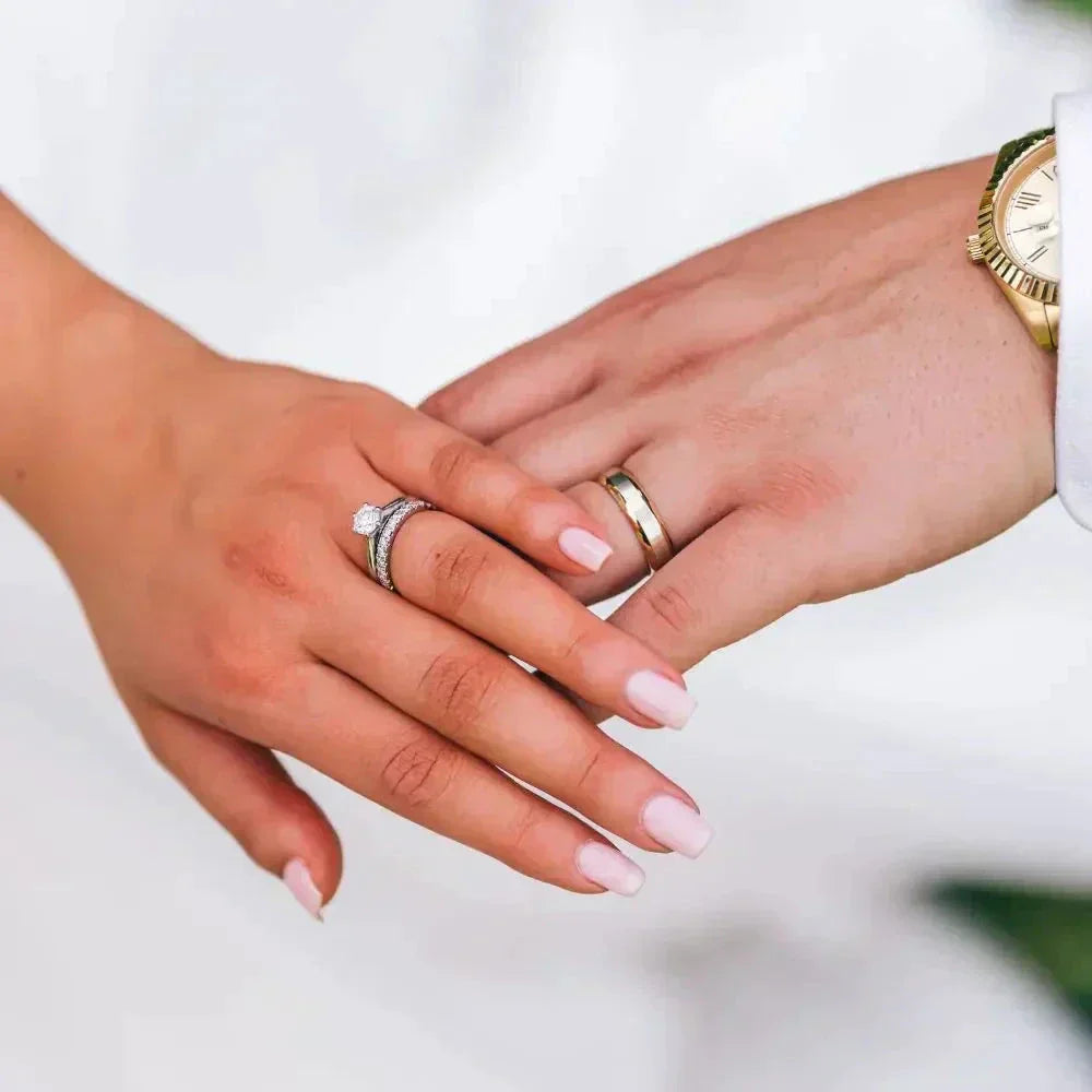 Two hands with horizon wedding band golden rings intertwined
