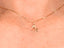 Close-up side view of the 18 k gold cat pendant on a person’s neck, capturing the pendant’s size and elegant outline.