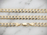 14K gold Cuban link chain on marble surface showing clasp detail