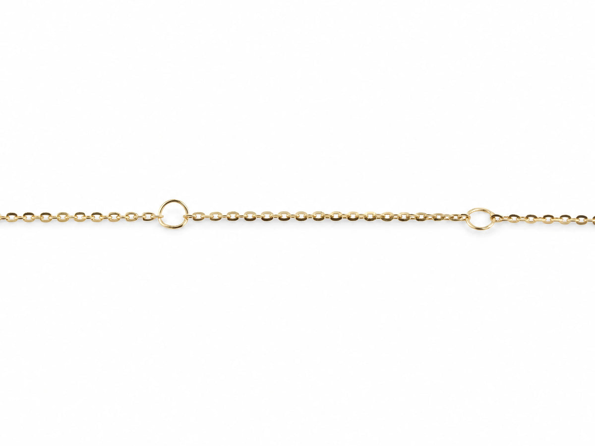 Close view of the fine yellow gold cable chain with the two larger fixed rings used to shorten the necklace to 17 and 16 inches