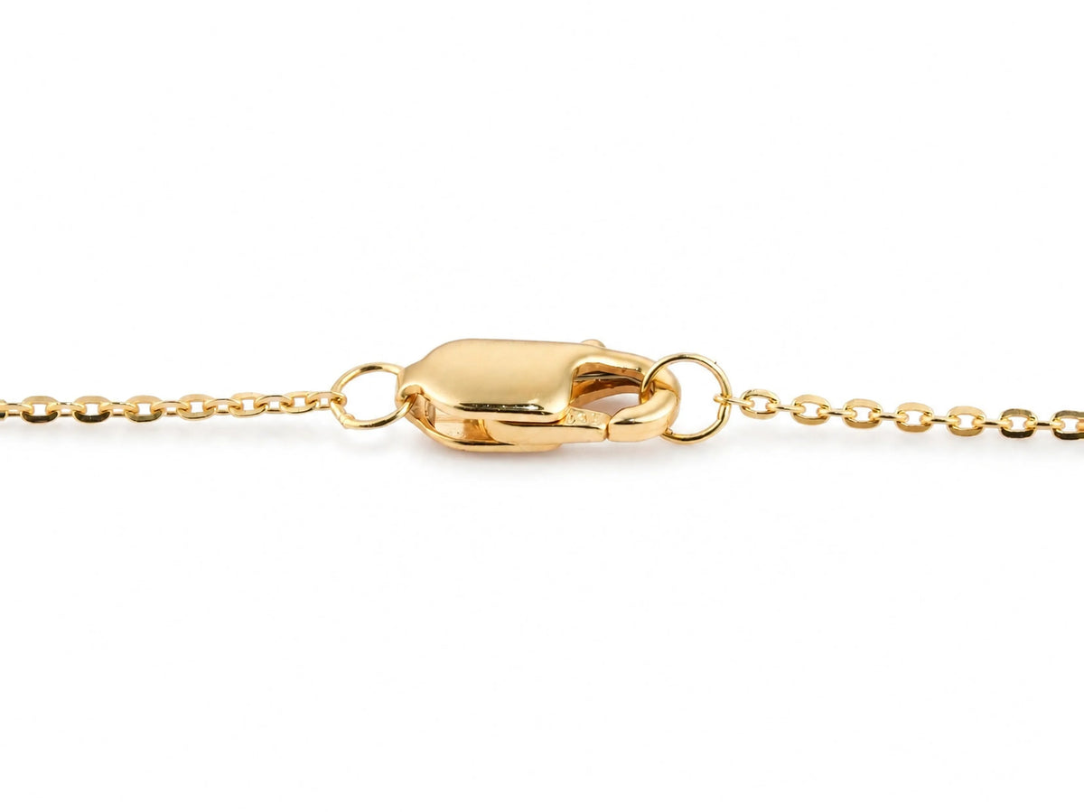 The lobster claw clasp of the station necklace, its polished gold body and the small hallmark stamp on the lower edge