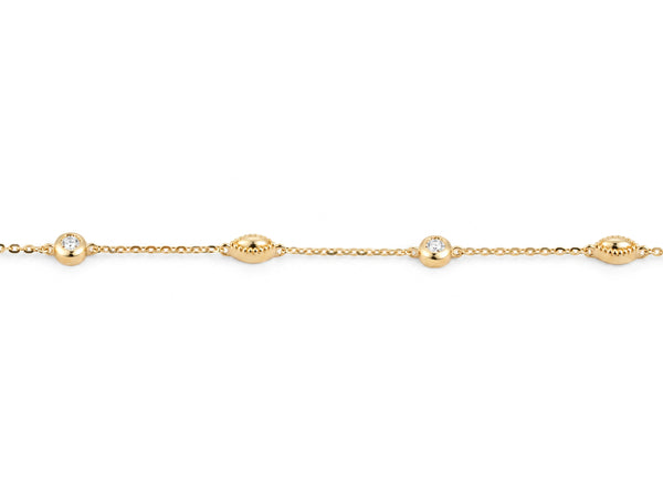 Close view of the alternating stations on the 14K yellow gold cable chain, a round diamond in a polished bezel beside a gold bead with a milgrain rim