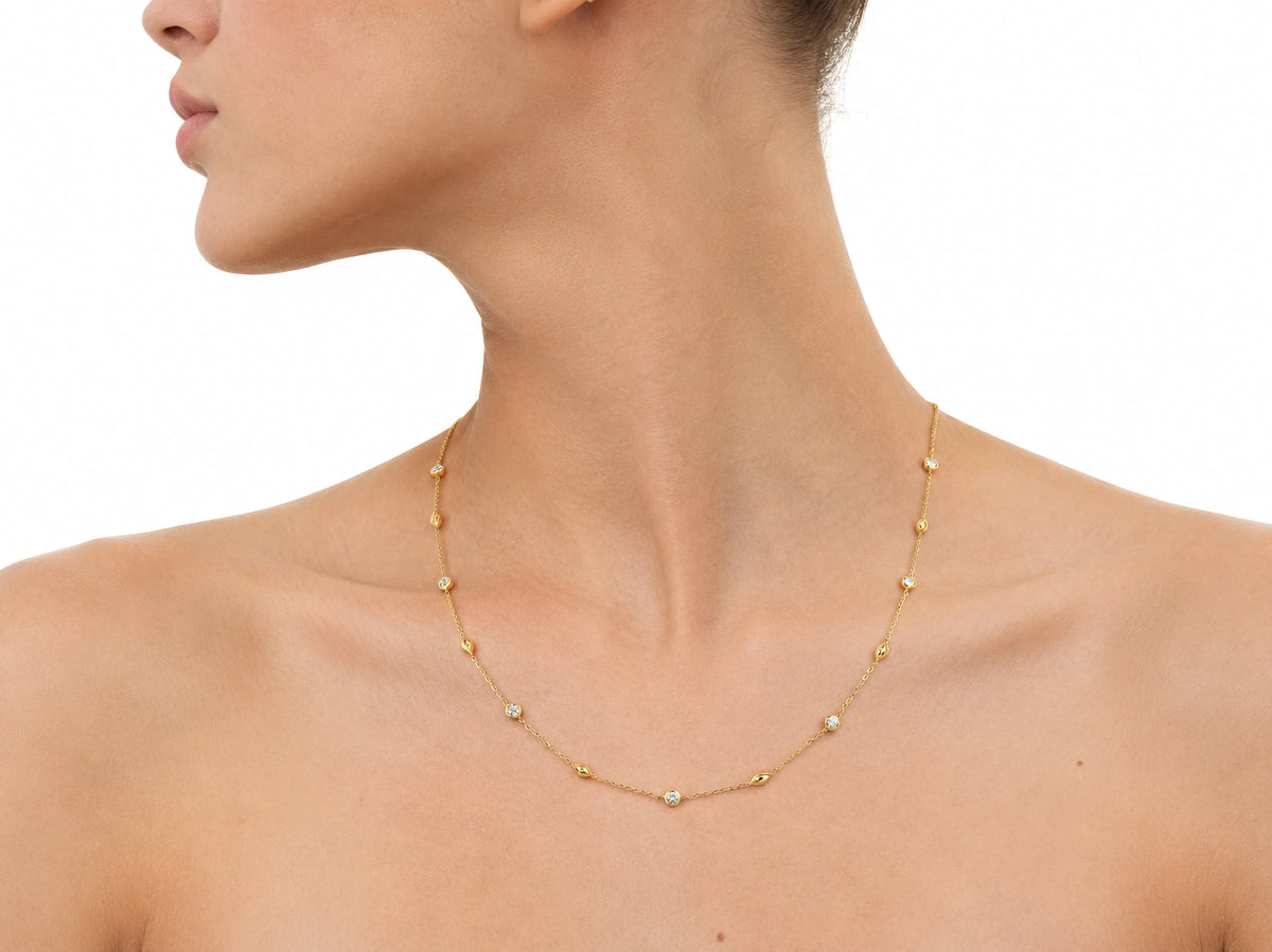 The station necklace worn across the upper chest, seen in profile with the jaw and mouth at the top edge of the frame