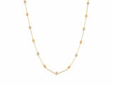 14K yellow gold station necklace laid out on white, round diamonds in gold bezels alternating with milgrain gold beads along the fine cable chain