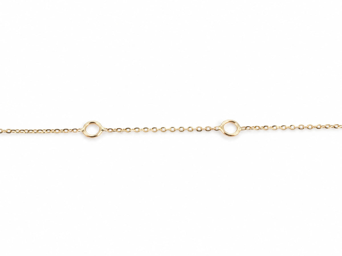 Close view of the fine yellow gold cable chain with the two larger fixed rings used to shorten the necklace to 17 and 16 inches