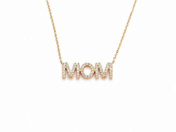 Close view of the MOM pendant, each letter pavé set with small round diamonds, the chain joining the outer edges of the two M's
