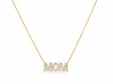 The MOM diamond pendant at the base of a fine 14K yellow gold cable chain on white, the chain curving up and out of the top of the frame