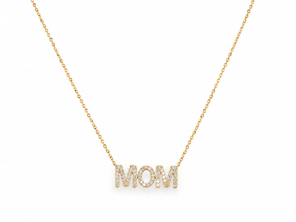 The MOM diamond pendant at the base of a fine 14K yellow gold cable chain on white, the chain curving up and out of the top of the frame